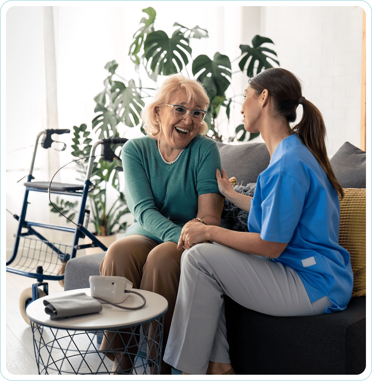 Elderly woman talking with caregiver on sofa.