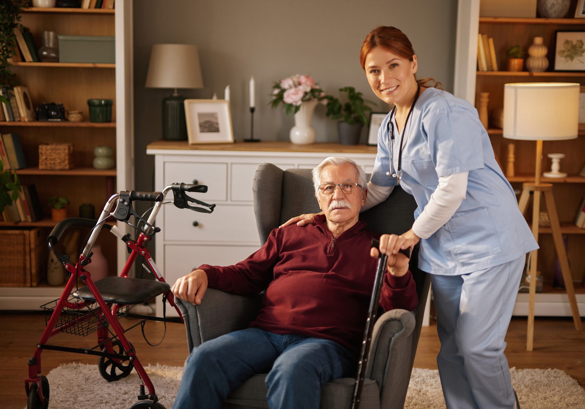 Elderly man with caregiver in living room.